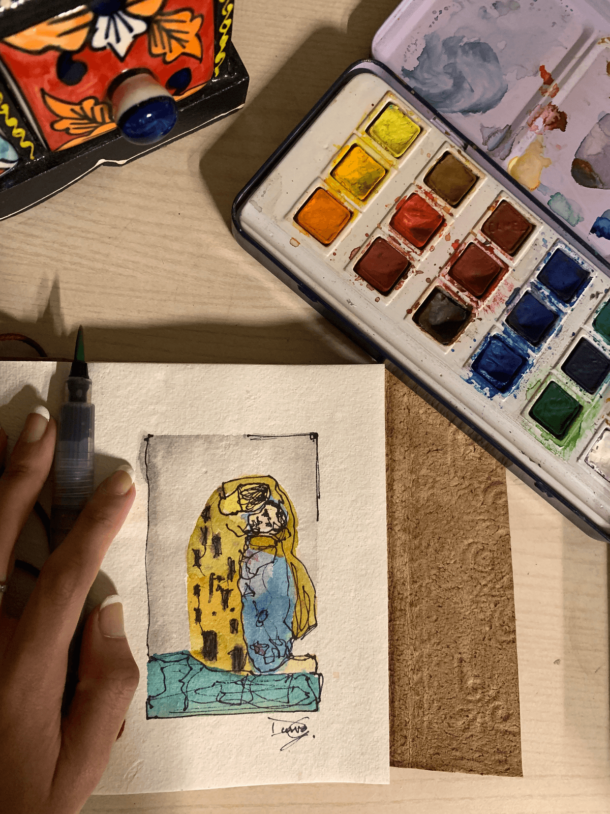 Watercolour study of Klimt's The Kiss, beside an open paint tin